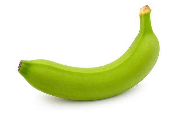 Uma banana verde inteira isolada em cima de um fundo limpo