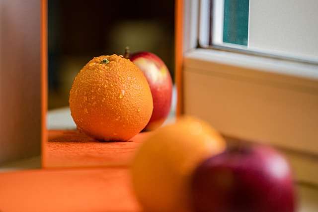 "Laranja seleta inteira com casca lisa de cor amarelo-clara e formato arredondado sobre um fundo neutro"