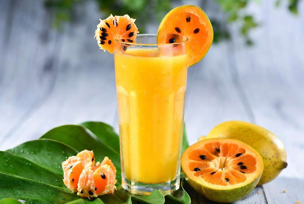 "Copo de suco de cajá natural com uma leve espuma na superfície, evidenciando a polpa da fruta."