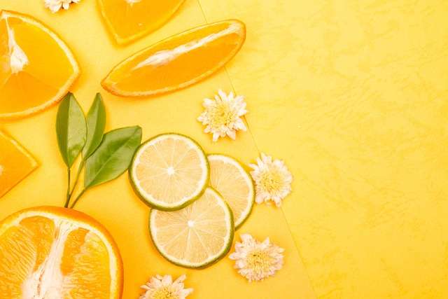 "Laranja-lima cortada ao meio e em várias fatias finas dispostas sobre uma tábua de cozinha, mostrando a polpa clara e sumarenta."
