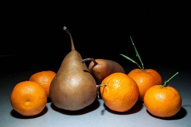 "Três laranjas-pera inteiras com formato ligeiramente alongado e casca lisa amarela-alaranjada, ilustrando frutas frescas para sumo."