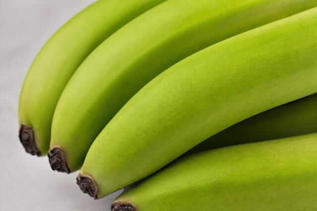 Banana d'Água Verde: Benefícios, Receitas e Como Consumir 2 Cacho de banana d'água verde fresca sobre uma bancada, ideal para o preparo de biomassa caseira.